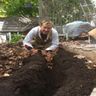Daniel putting leaves over garden soil