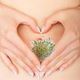 Belly with grass and hands making heart